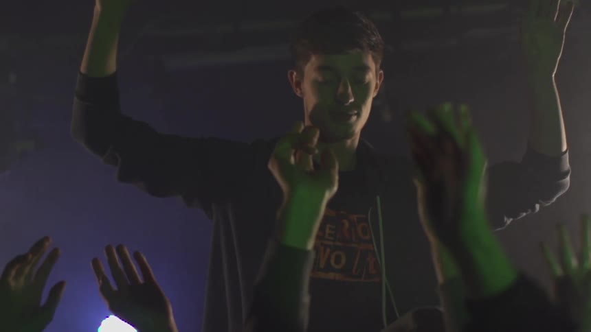 Man waves his hand and audience does the same