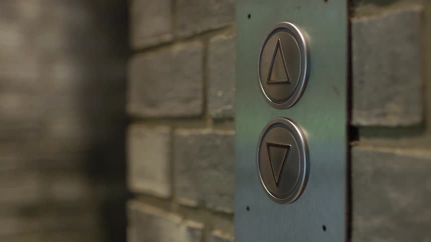 Person pushes the up button on an elevator and walks away