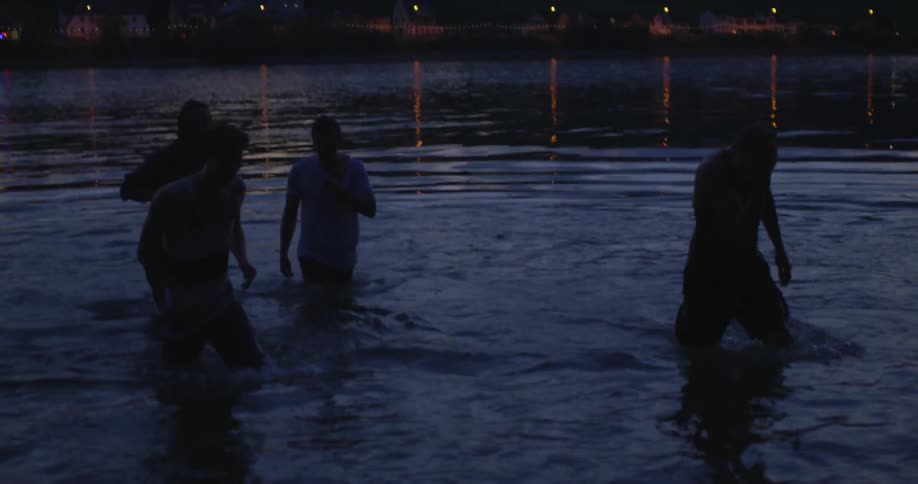 Men in a lake at night