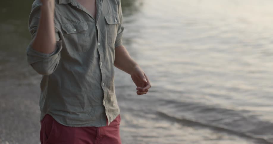 A man tosses a ball to another man on a beach