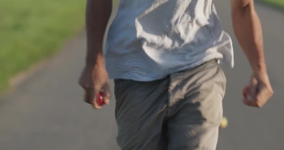 Man runs on a road with apples in both hands