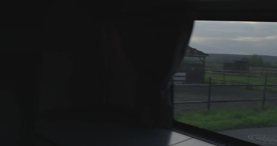 A camper is driving onto a ranch on a cloudy day