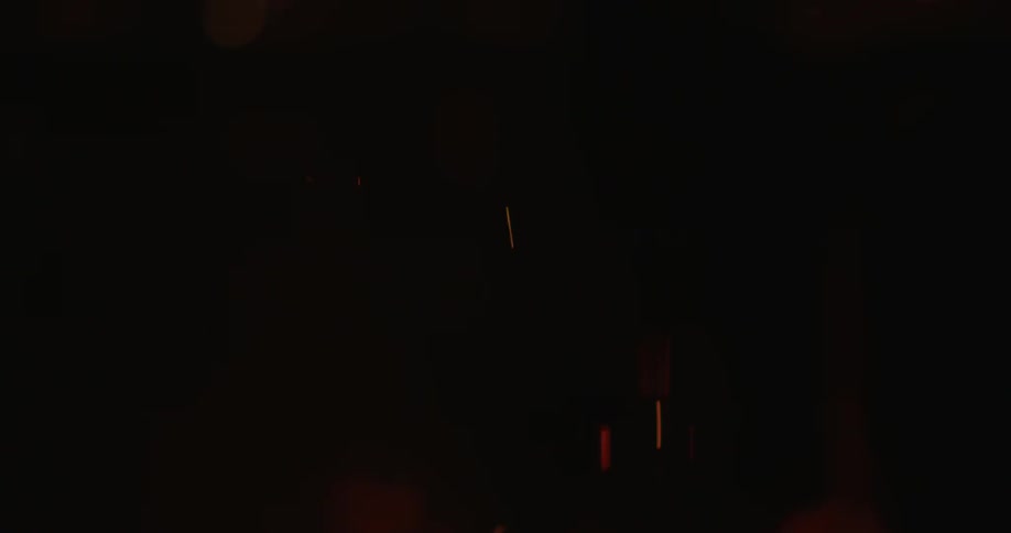 Flames and smoke are rising from a fire at night