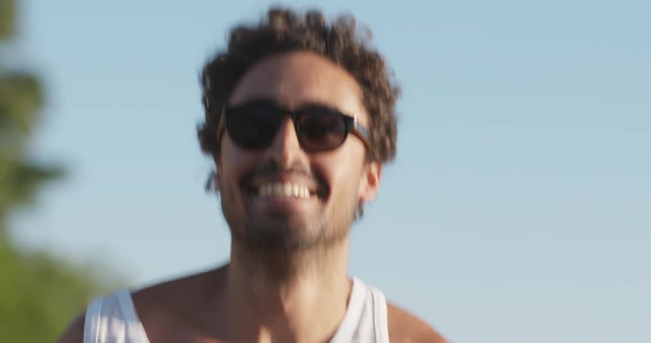 A man smiles as he runs on a sunny day
