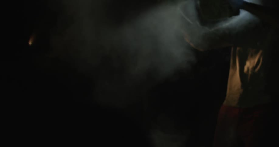 A person swings fabric around billowing steam