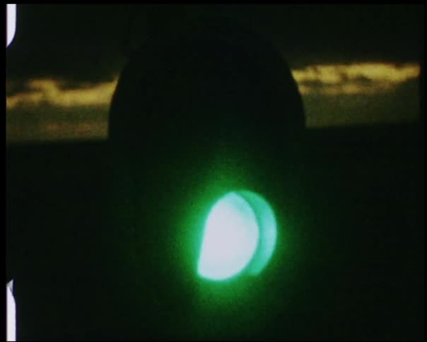 A stoplight flashes from green to red at dusk