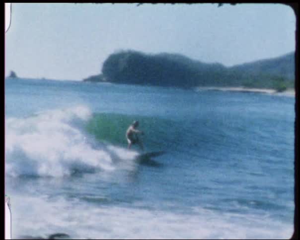 A surfer rides a wave to shore