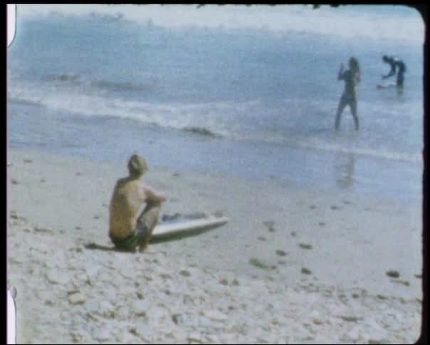 A man watches the waves come in on the coast