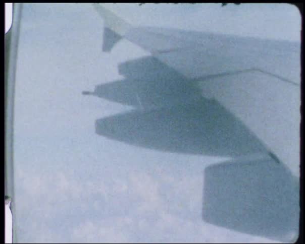 The flying airplane is above the clouds through the window
