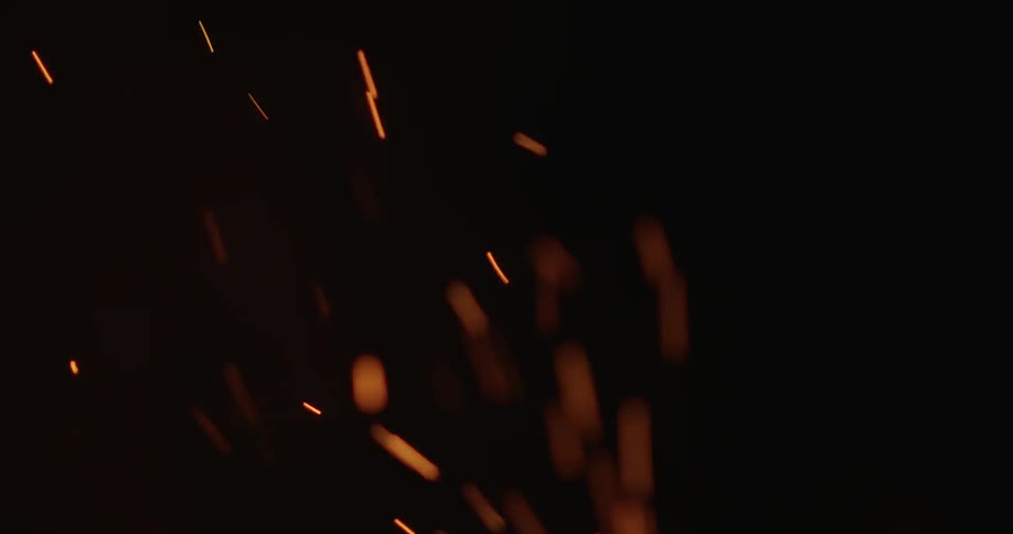 Sparks are rising from a campfire at night