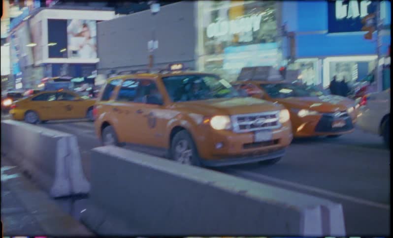 Taxi cubs idle in traffic in a city at night