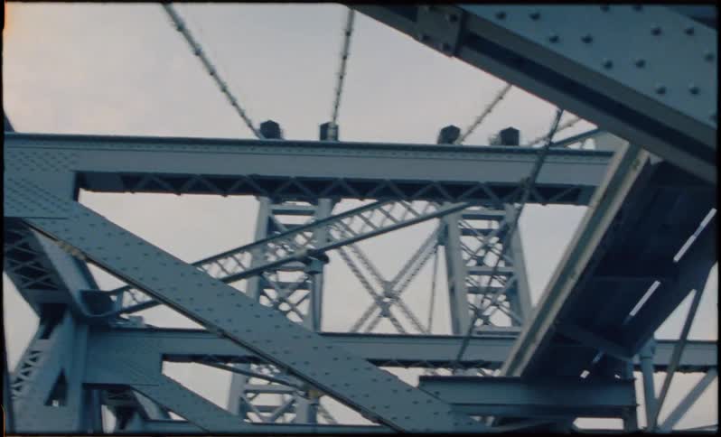 A steel bridge is filmed from the road