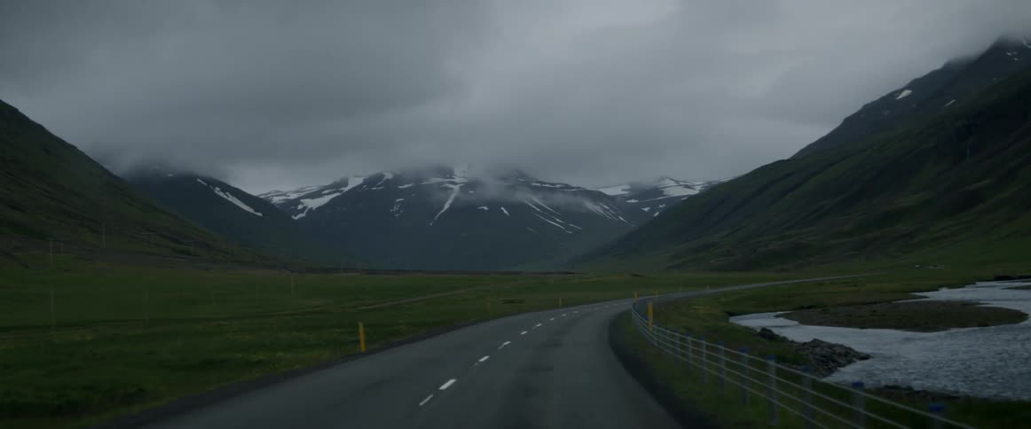 A car drives down a mountain road