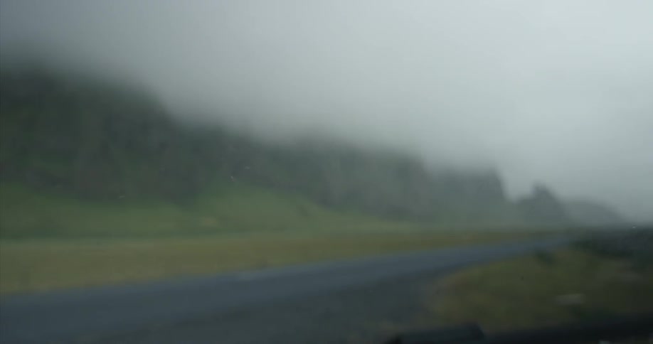 Windshield wipers are removing rain from a car window