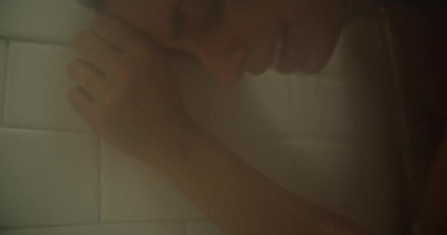 A woman cries in the shower
