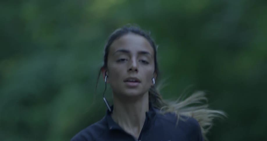 A woman is jogging outside by the forest