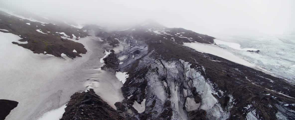 Fog covers a glacier landscape during the day