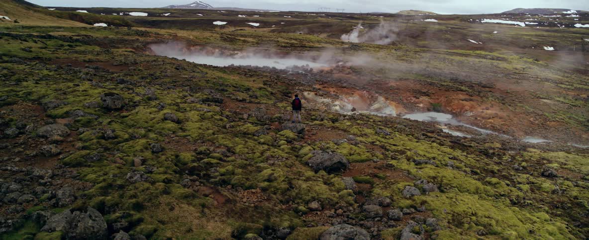 Person looks at steaming springs