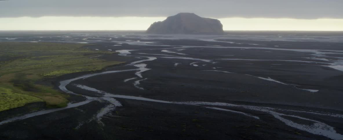 A black gravel plain twisted with rivers
