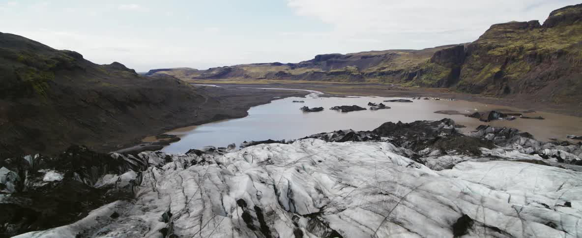Striped ice near a river and mountain