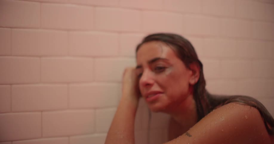 A woman cries as multicolored lights flash in a shower