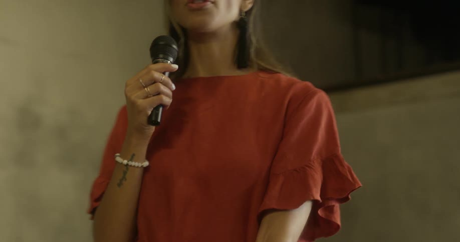 A woman speaks into a handheld microphone