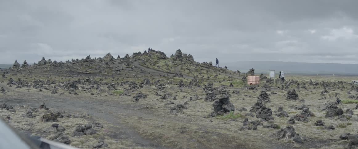 A person walks up a rocky hillside