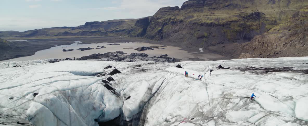 Climbers are gathering on top of a glacier during the day