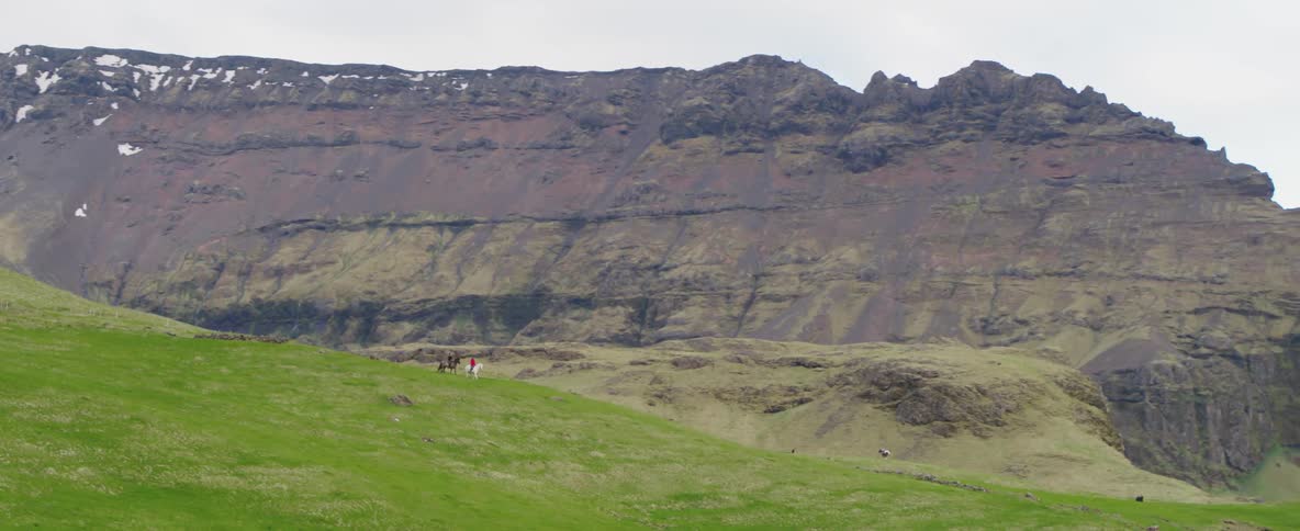 People go horseback riding near mountains