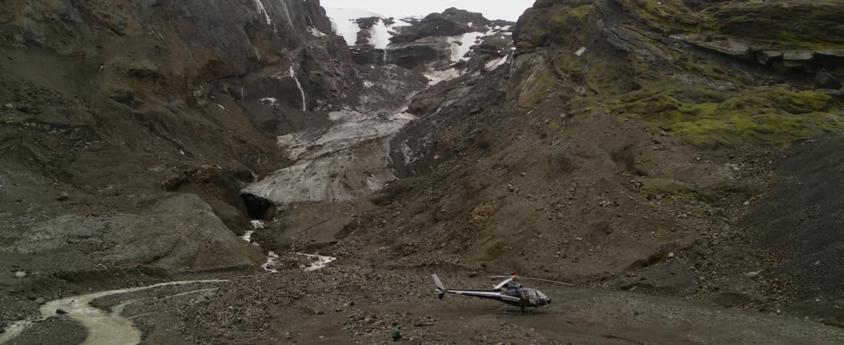 A helicopter at the base of a mountain