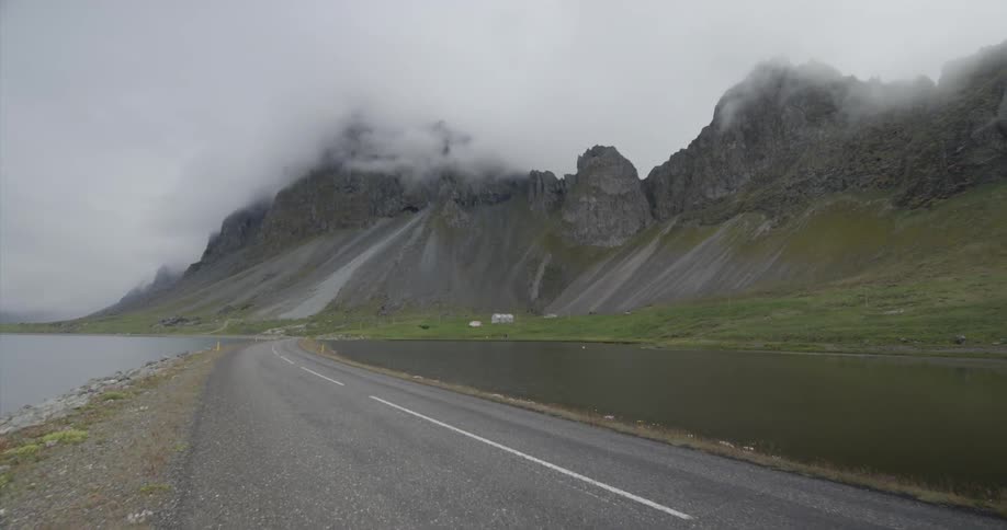 Fog and clouds hang over coastal mountains during the day