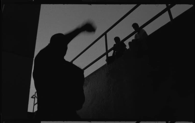 A man is shadow boxing while two people are watching