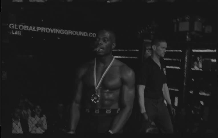 A man celebrates a boxing victory and receives a title belt