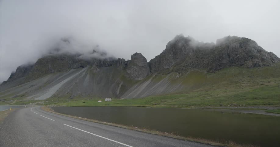 Fog hangs above the water and mountain