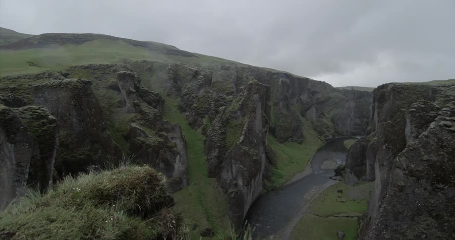 Tall cliffs tower over the stream below