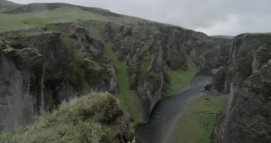Tall cliffs tower over the stream below