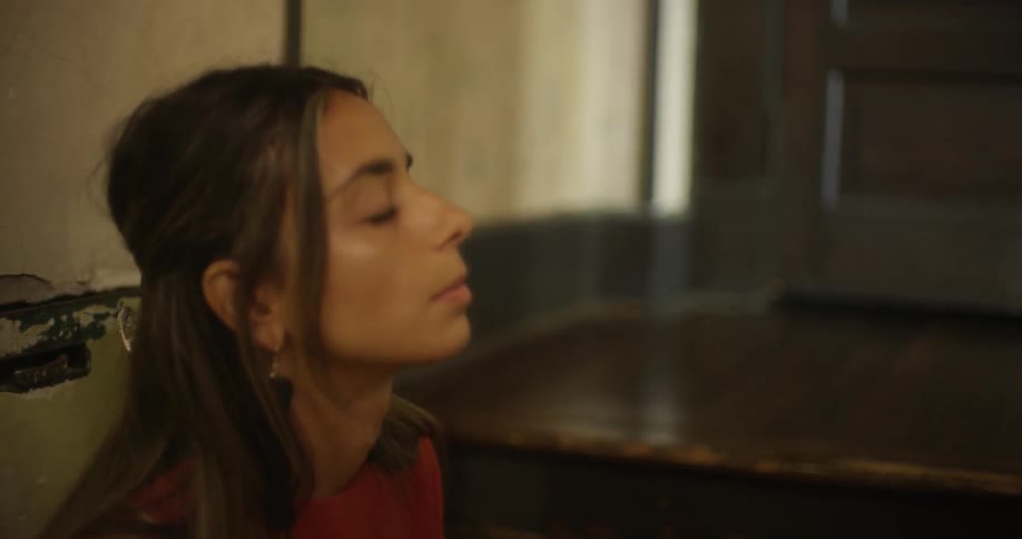 A woman leans back and mutters to herself