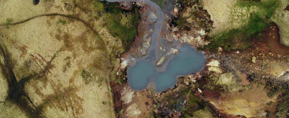 A steaming pond surrounded by rocks