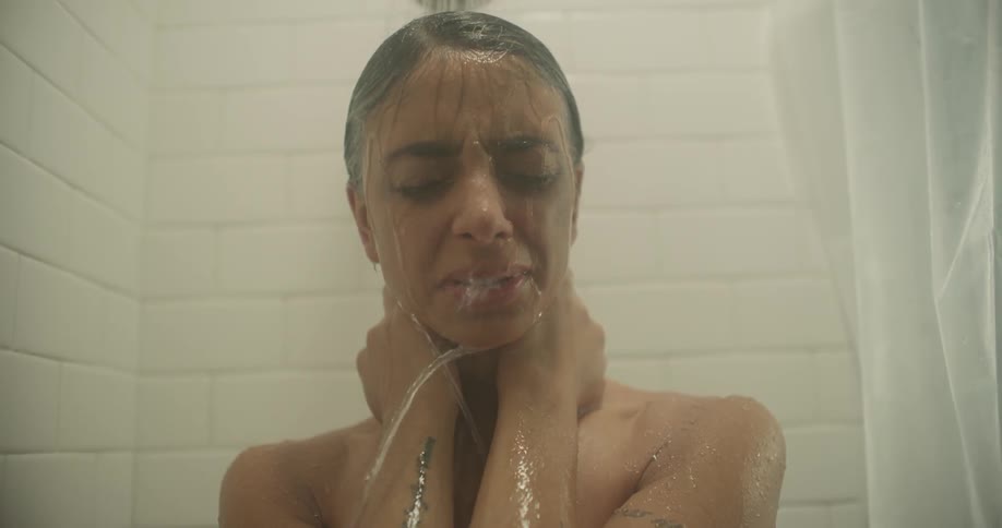 Woman takes a shower with eyes closed
