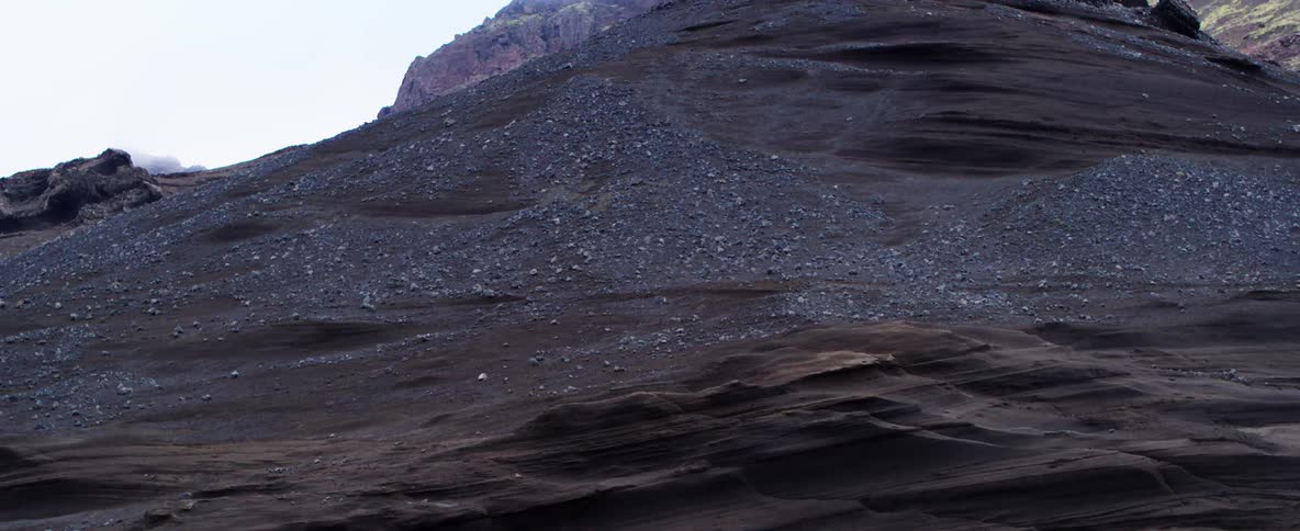 A red rock covered hilly landscape with some fog at higher elevation
