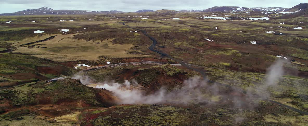 Smoke steams up from grassy hills