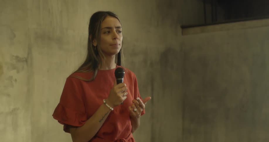 A woman talks into a handheld microphone