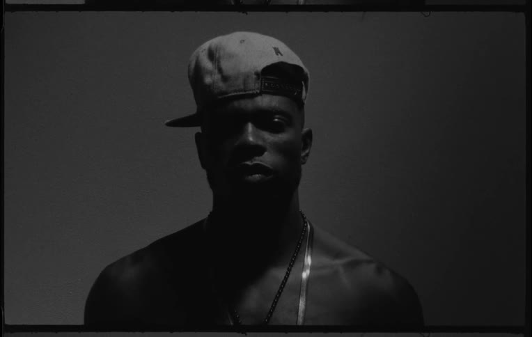 A black man moves his head as he is staring forward
