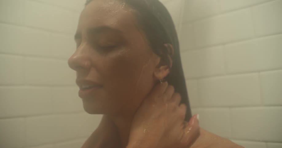 A woman stands in a shower