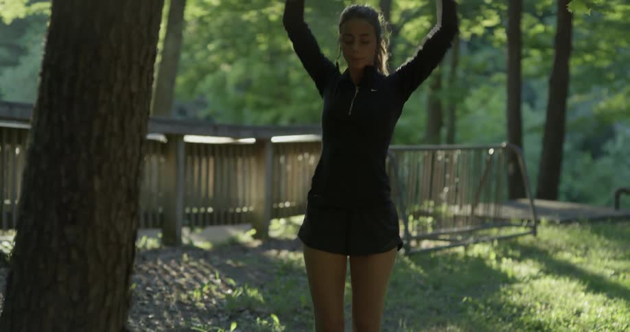 Woman stretching outdoors and warming up on an early morning