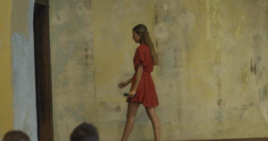 A woman walks off stage with a microphone