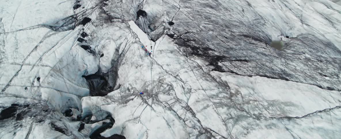Hikers climb a snowy mountainside