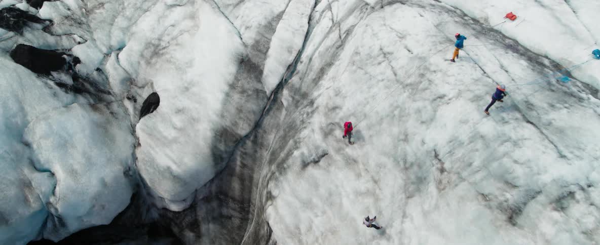 Hikers climb a snowy mountainside