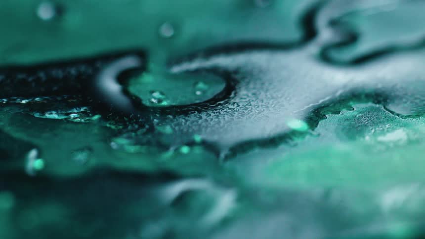 Green liquid beads on top of a surface