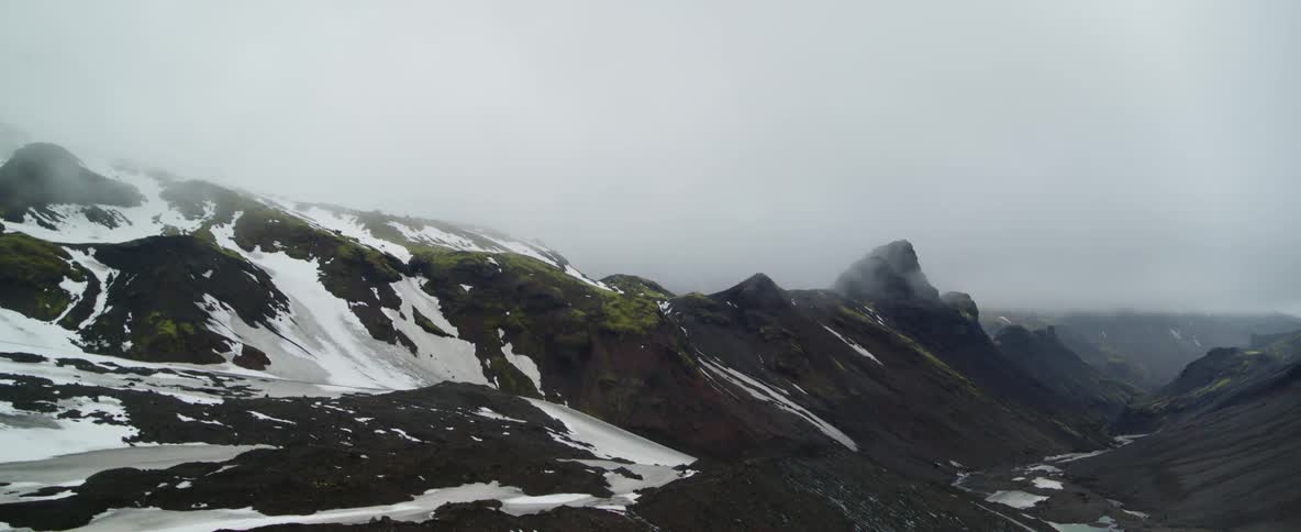 Mist floats above a snowy mountainside